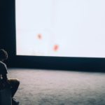 Man Sitting in Front of Turned-on Screen