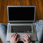 Person in Blue Denim Jeans Sitting on Floor Using Macbook Air